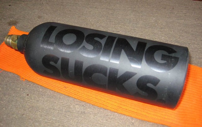 Back side of 20oz co2 tank is mask anodized with "Losing Sucks."
