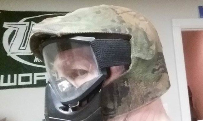 Chuck modeling the side profile of his camo helmet with a set of Tiger Stripes in them.