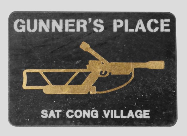 Brass sticker for Gunner's Place at Sat Cong Village. Sticker photographed off of Bob Fowlie's tackle tool box.