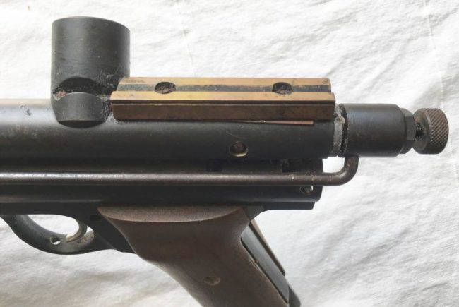 Brass sight rail screwed onto back of body (with adhesive strip underneath?